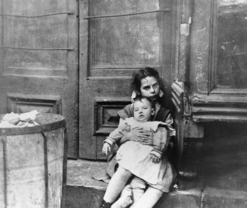 Girl Sitting on Doorstep with Baby on Her Lap